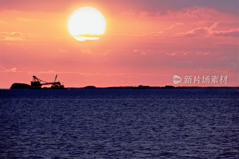 海上夕阳下的工程设备剪影