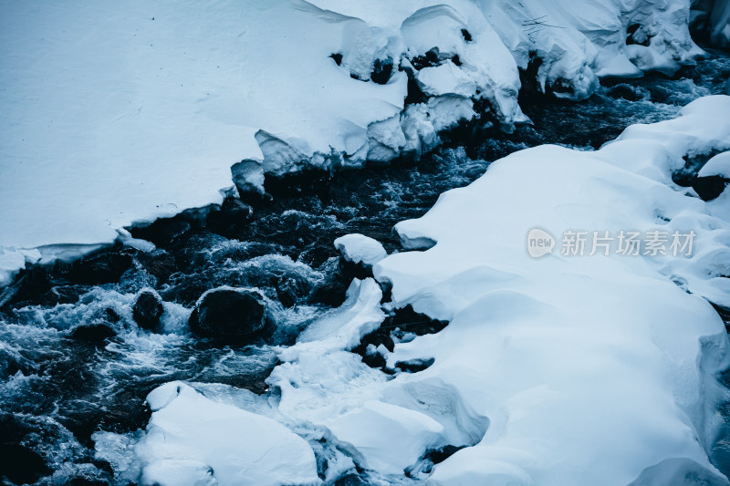 东北长白山冬季雪地上流动的河流