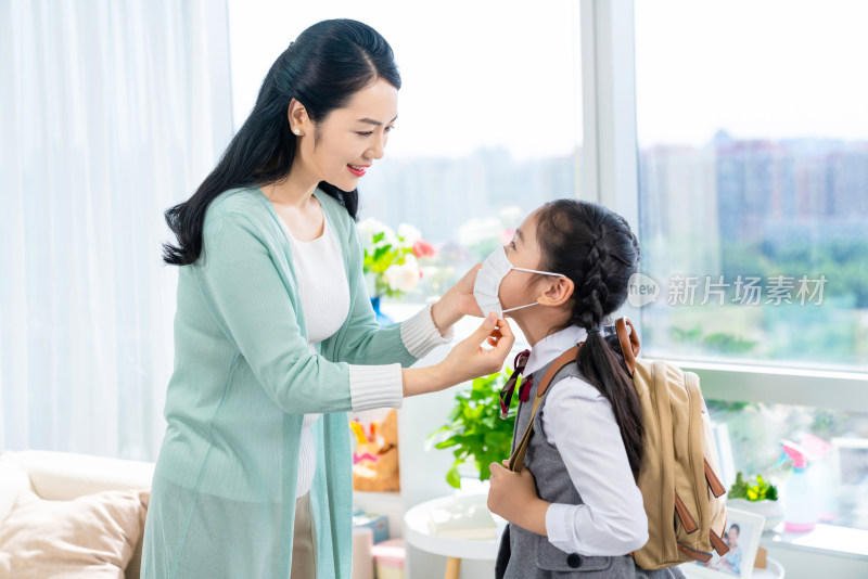 妈妈给女儿戴口罩