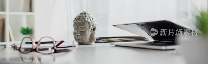 办公桌上的佛像与笔记本电脑