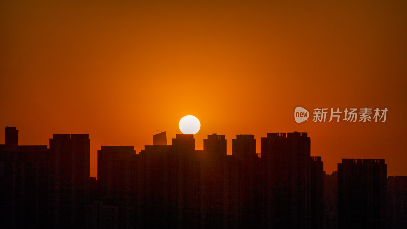 清晨城市高层住宅与日出太阳