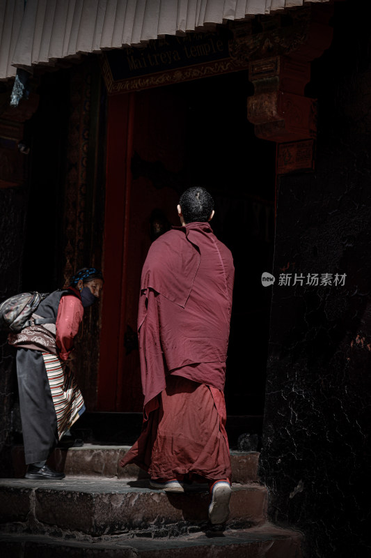 身着僧袍的僧人进入寺庙内