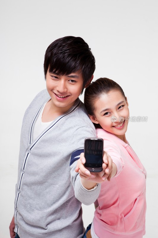 快乐的年轻情侣展示手机