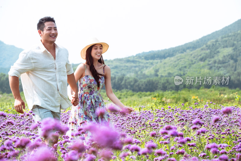 青年夫妇手牵手走在花海里