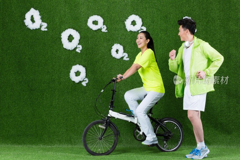 草地创意年轻情侣骑自行车