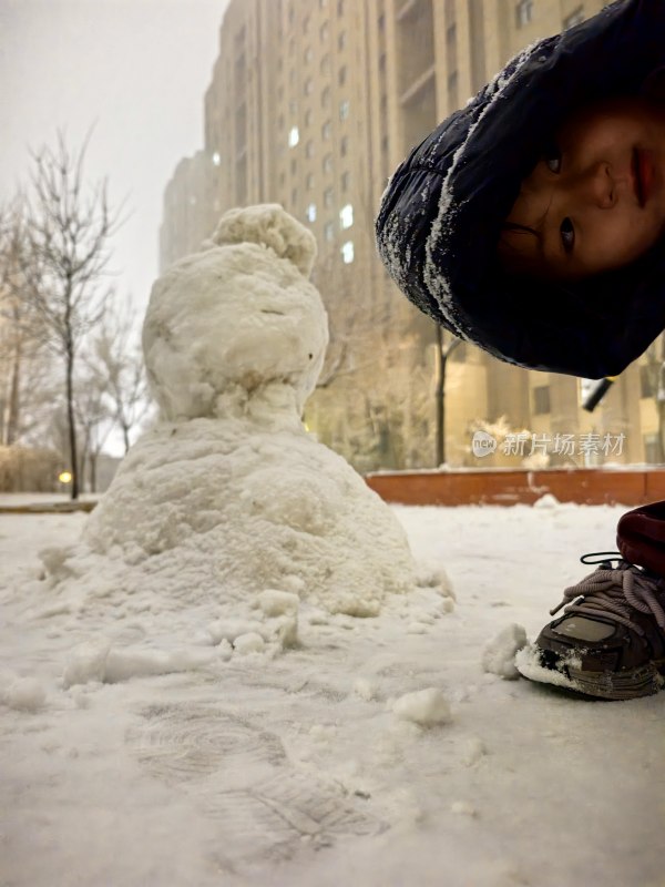 小孩与雪人在雪地中的场景