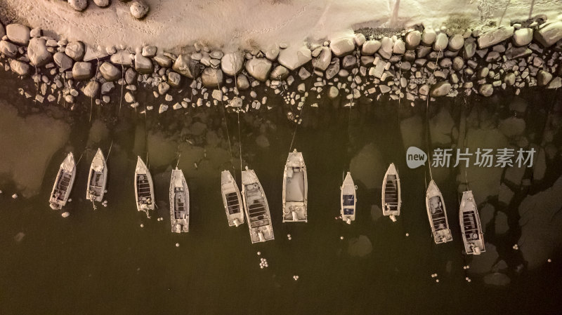 航拍俯瞰威海经区崮山蒲湾雪后海岸停泊渔船