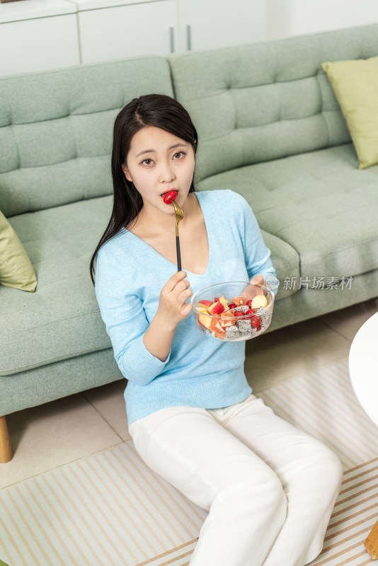 年轻女士在家吃水果沙拉