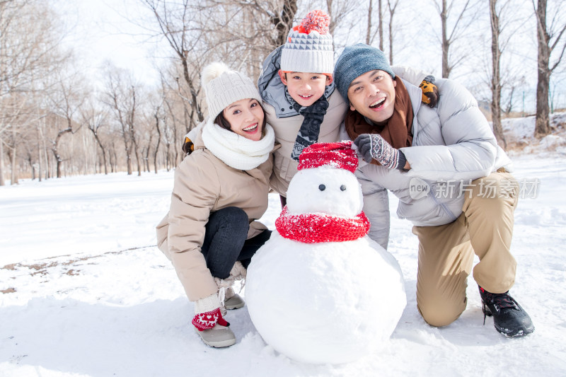 一家三口在雪地里堆雪人