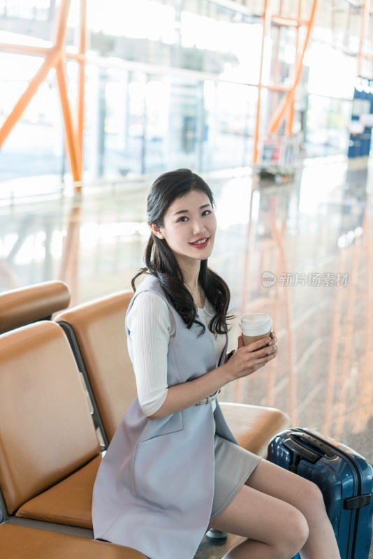 年轻商务女士在机场喝咖啡