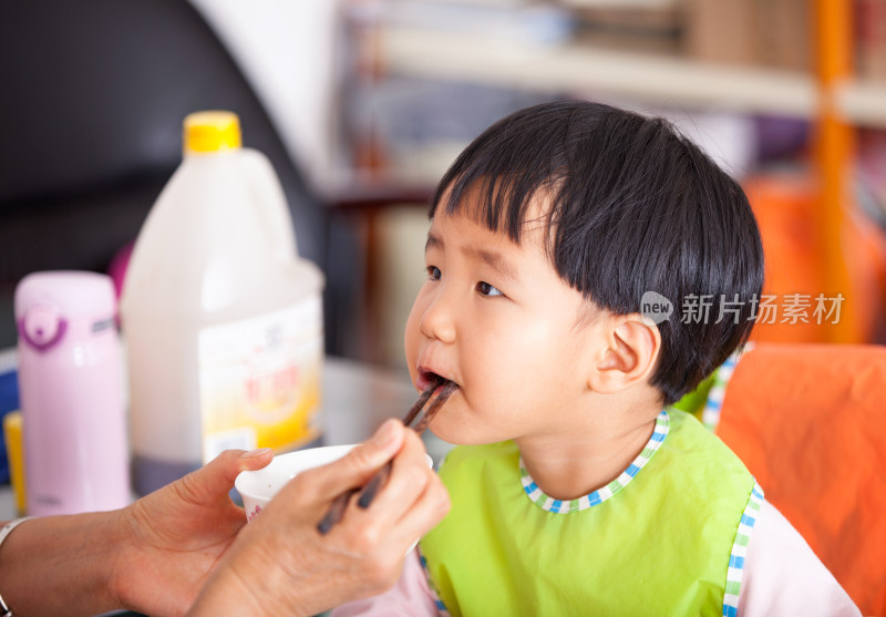 正在给亚洲面孔的小女孩喂饭