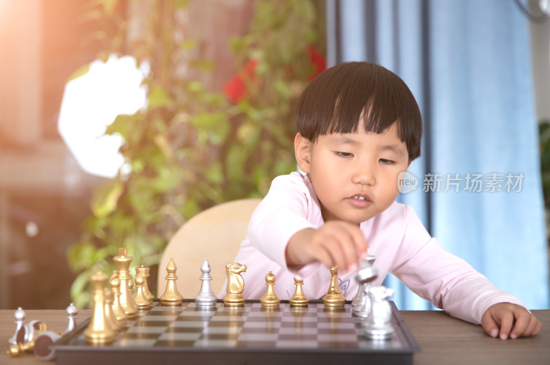 可爱的中国小女孩在学习下国际象棋