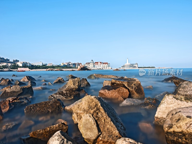 青岛海边礁石与远处建筑景观