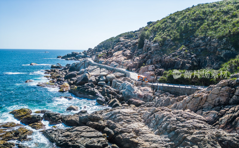 阳光下的海南三亚海岸线上礁石沙滩海浪浪花