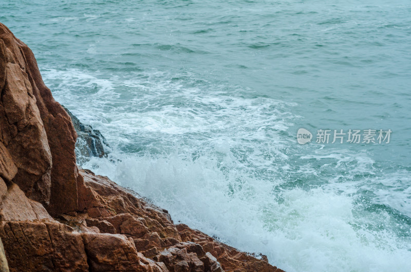 海边飞溅的浪花拍打着礁石