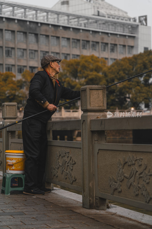 老人在公园里下棋和钓鱼