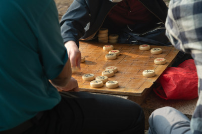 几个男人在户外下中国象棋的场景