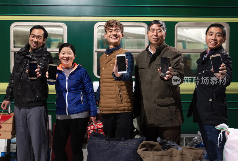 站在火车月台上展示手机的旅客