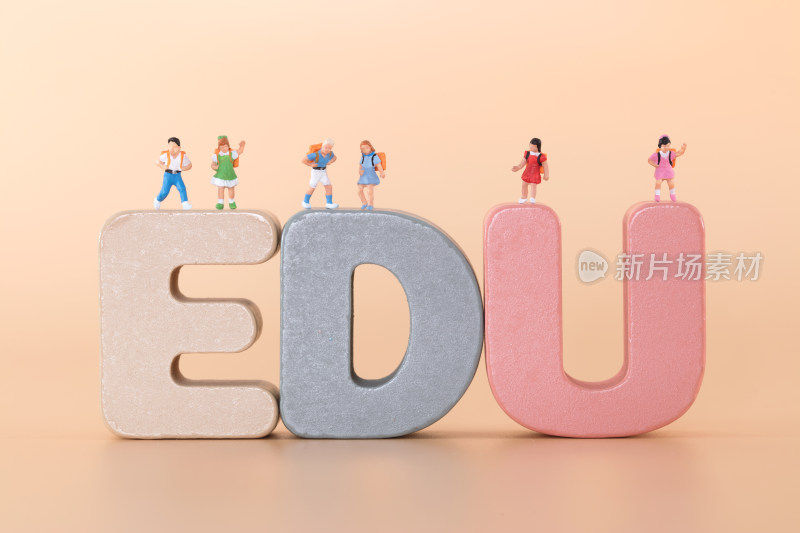 一群小学生微缩人偶模型站在英文字母EDU上