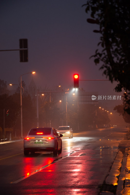 雨夜街道红绿灯下的行驶车辆