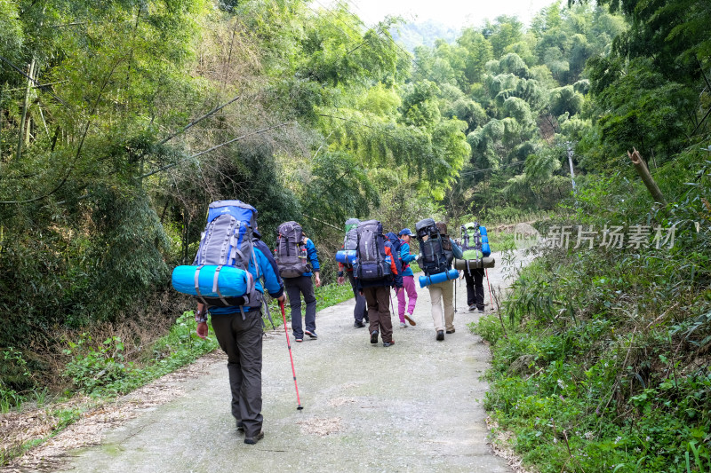 户外徒步旅行者在山林小路前行的景象