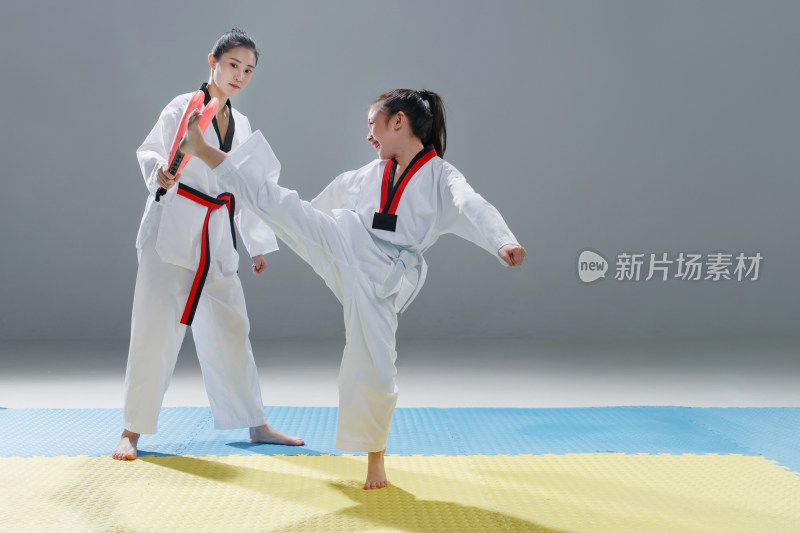 年轻教练教小女孩学跆拳道