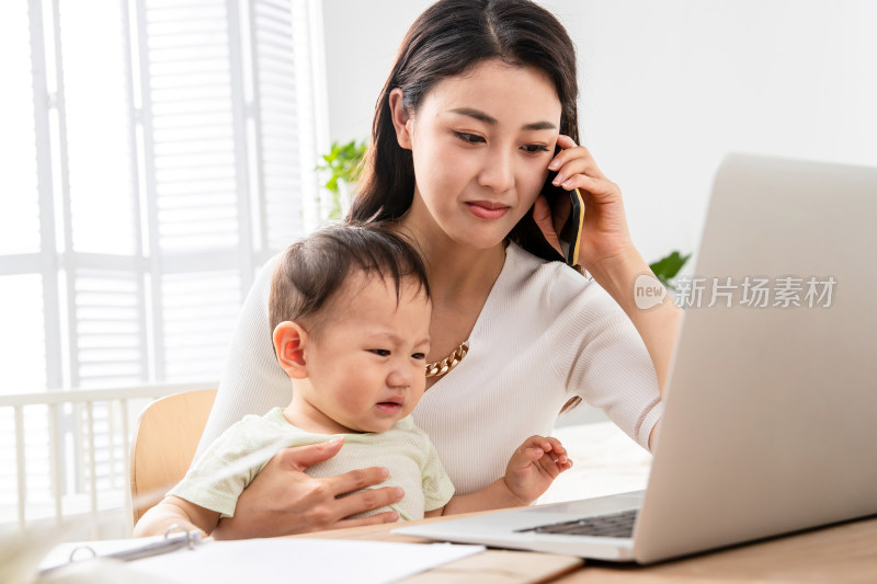 年轻妈妈带着宝宝看电脑