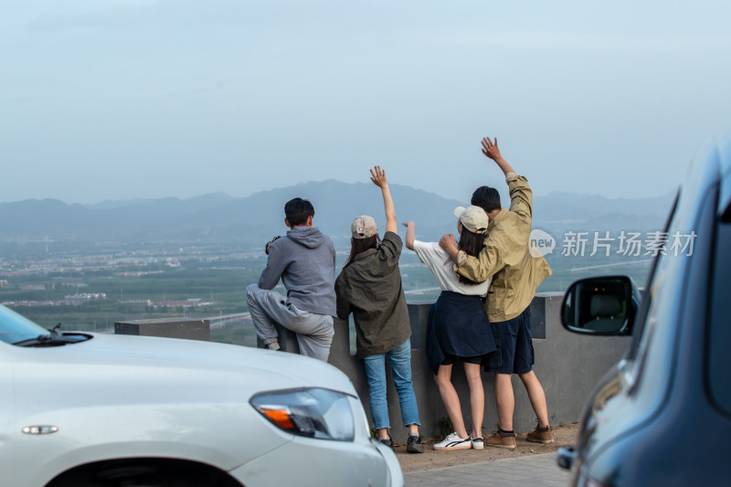 快乐的青年朋友站在山顶看风景