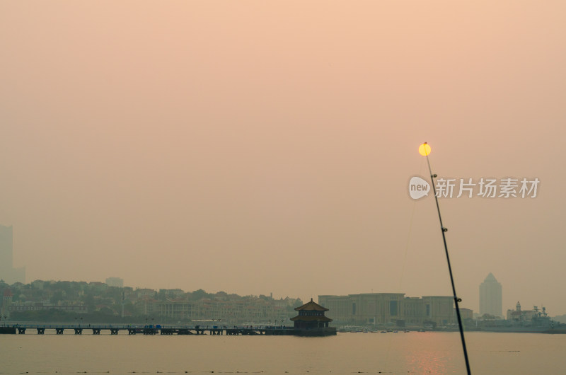 青岛海边日出时的城市与栈桥景观