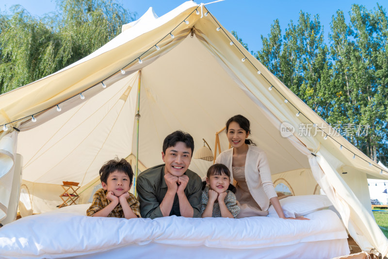 一家人趴在露营地的帐篷里