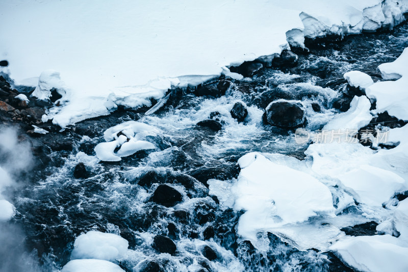 东北长白山冬季雪地上流动的河流