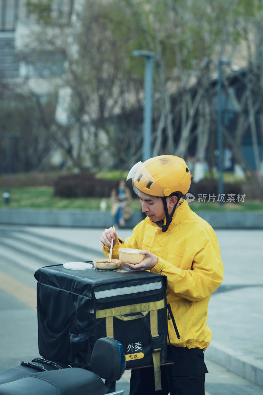 在户外吃饭的青年外卖员