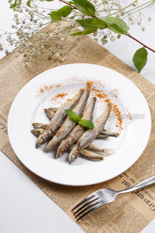 日式铁板煎椒盐多春鱼摆放在英文包装纸上
