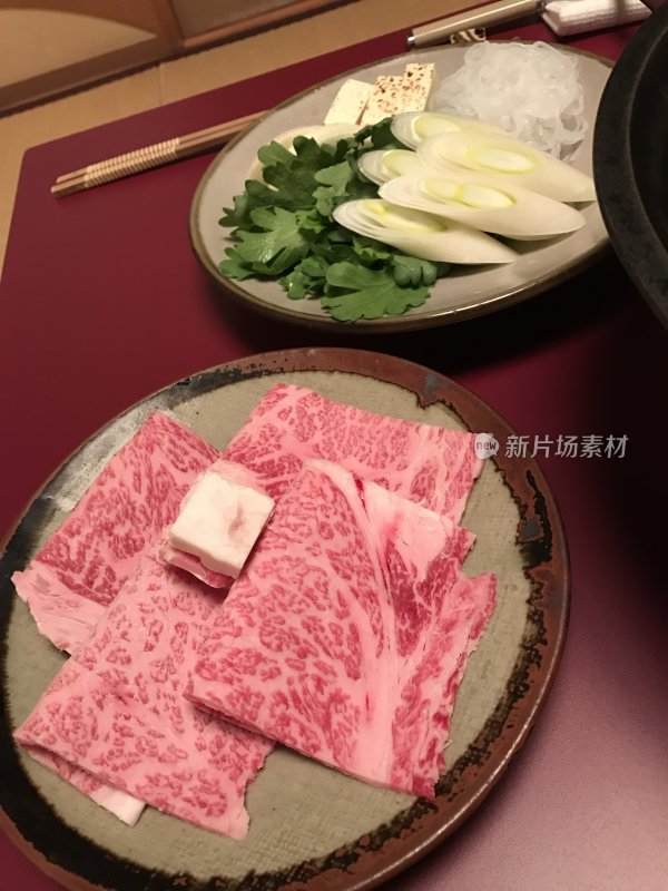 桌上摆盘精致的牛肉片与配菜\和牛