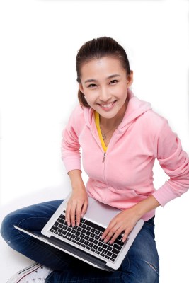 年轻女人坐在地上使用笔记本电脑