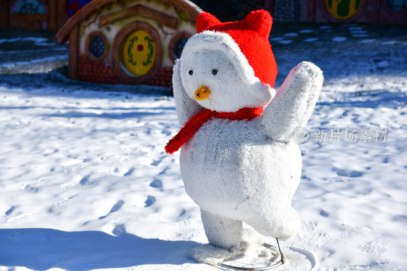 雪地里戴着红帽的可爱雪人玩偶