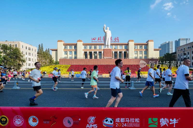 成都马拉松选手奔跑在四川体育馆前