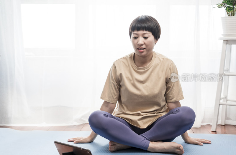 使用平板电脑学习练习瑜伽的中国女性