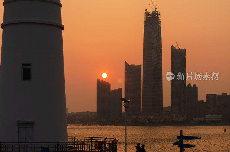 青岛奥帆中心灯塔，对岸落日下的海天中心