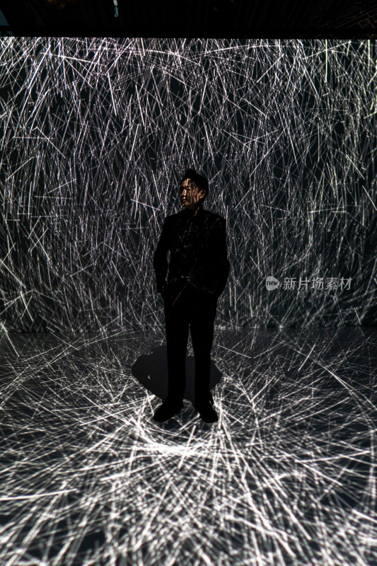男子站立于光影线条艺术场景