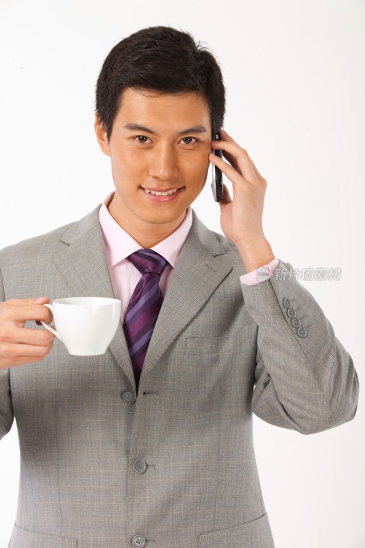 商务男士端着咖啡杯打电话