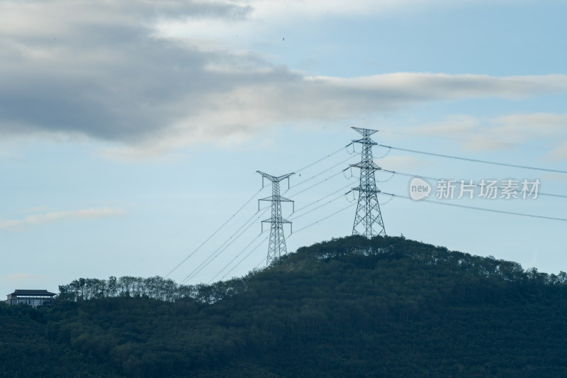 山坡上矗立的高压输电塔远景