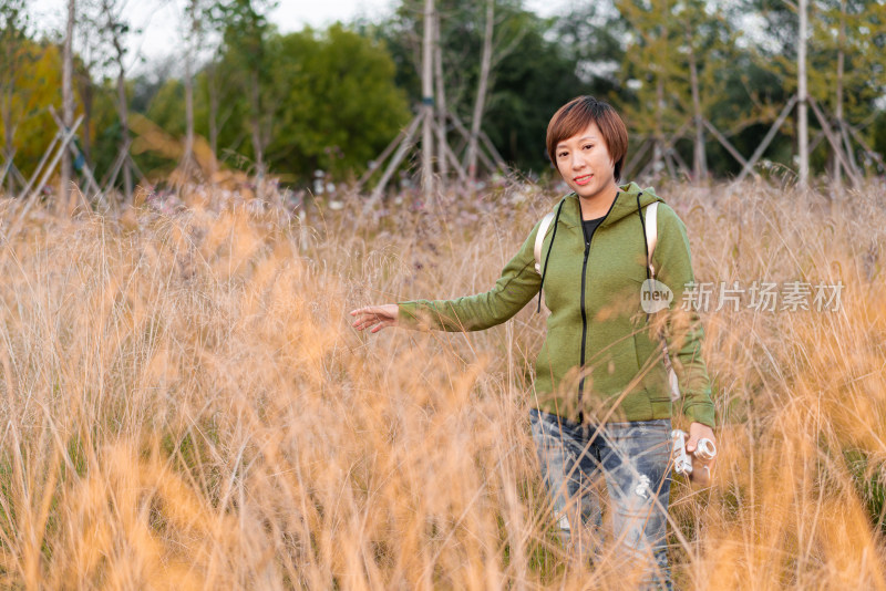 站在干枯草丛中的中国籍女性
