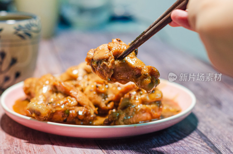 夹起一块鸡腿肉，一个中国传统花纹陶瓷水杯