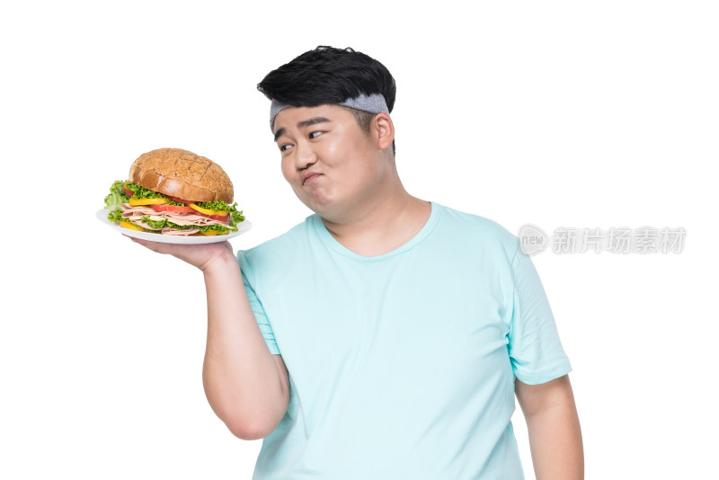 肥胖的年轻男子拿着汉堡