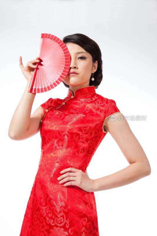 棚拍节日身穿红色旗袍的年轻女人拿着扇子