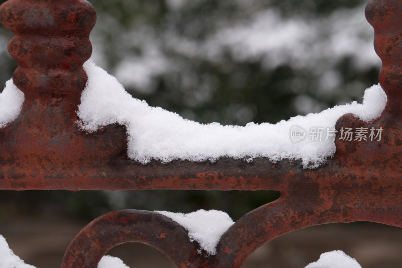 围墙的金属栅栏上堆积着洁净的白雪