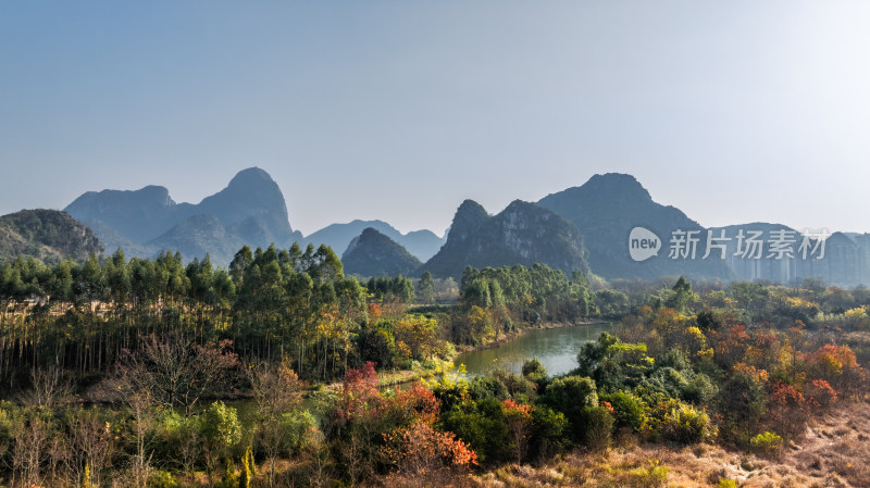 秋天阳光下桂林山边桃花江两岸的绿树和红叶