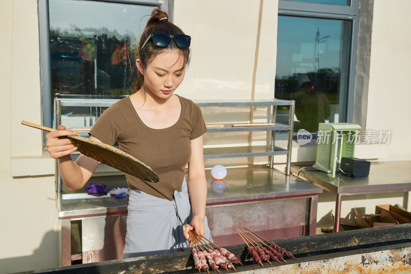 卖力烤羊肉串的美女