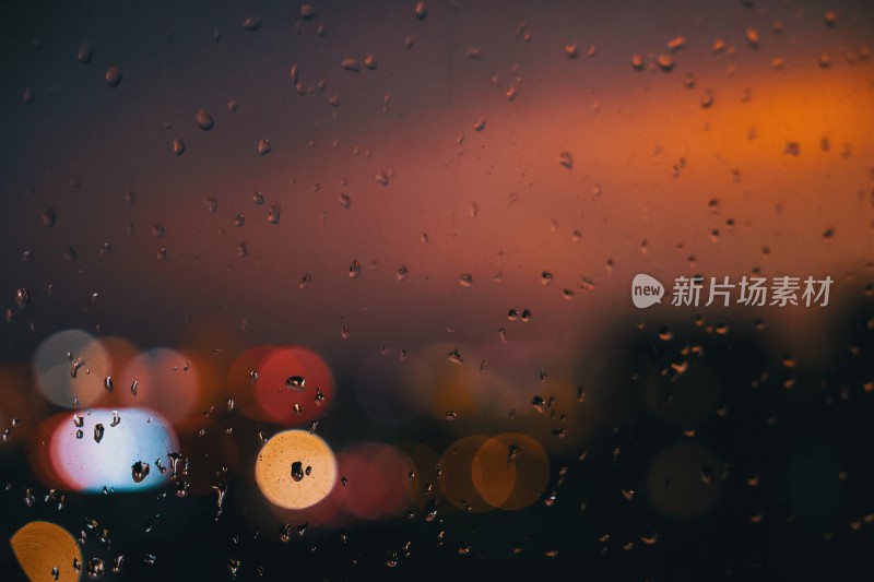 带雨珠的窗户透出暖色调灯光